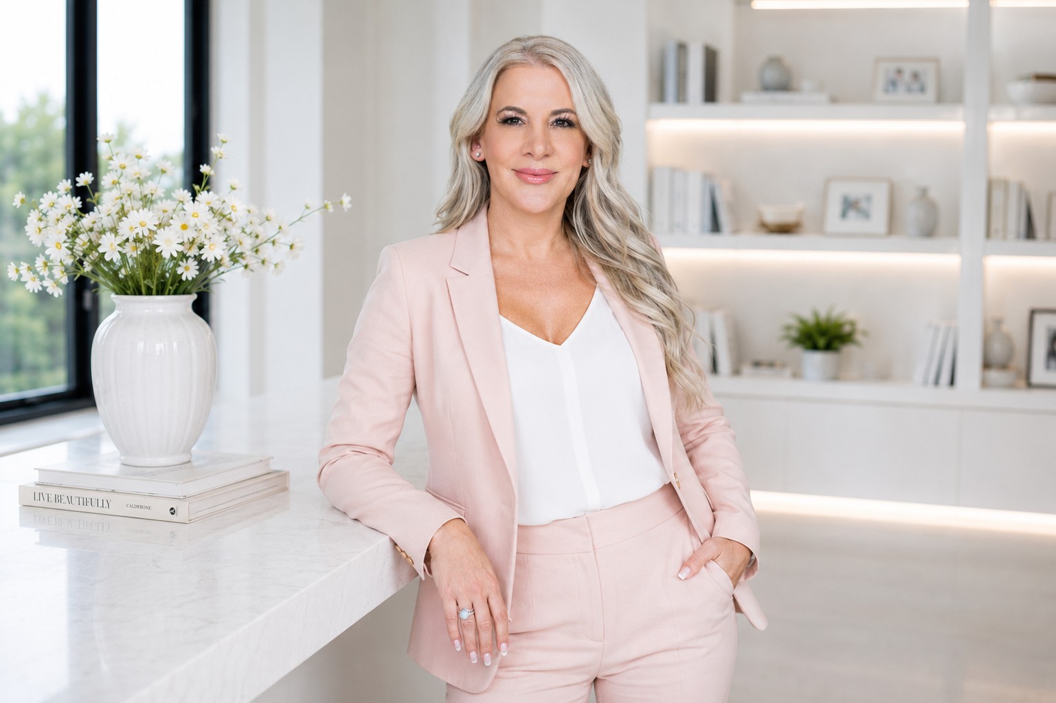 Dr. Julie Wilkes in a bright room with white shelves and fresh white flowers